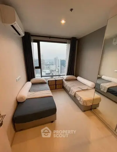 Modern bedroom with twin beds and city view, featuring large mirror and air conditioning.