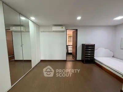 Spacious bedroom with mirrored closet and modern air conditioning