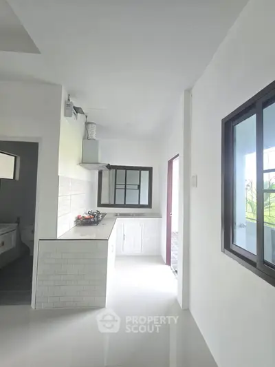 Modern kitchen with sleek design and large windows for natural light.