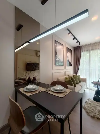 Modern living room with dining area, stylish decor, and large window for natural light.
