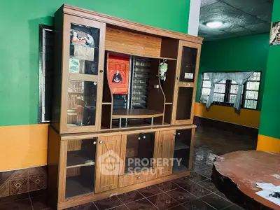 Spacious living room with wooden entertainment center and vibrant green walls