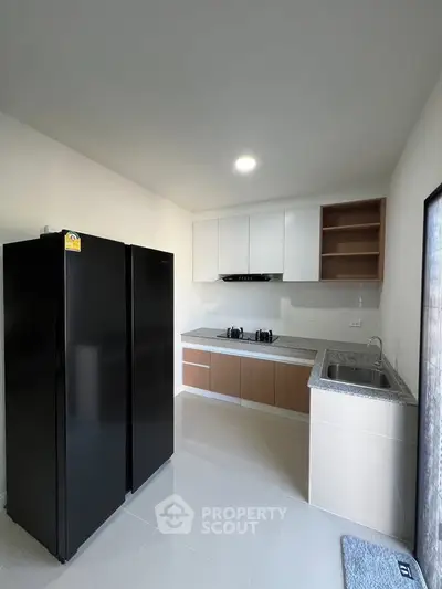 Modern kitchen with sleek black fridge and minimalist design