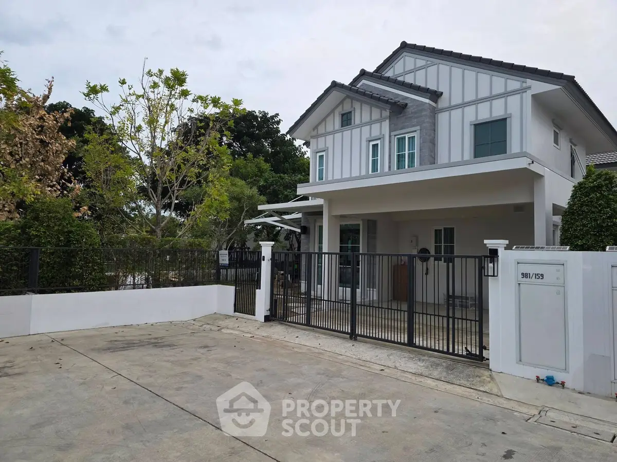 Modern two-story house with gated entrance and spacious driveway