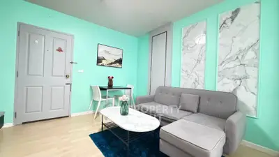 Chic modern living room with turquoise walls, marble accents, and cozy gray sofa.