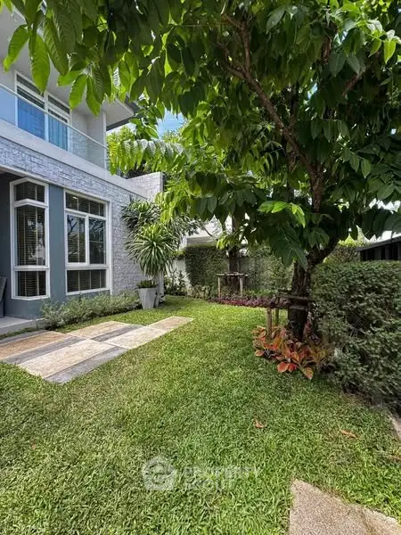 Charming garden view of modern home with lush greenery and elegant architecture.
