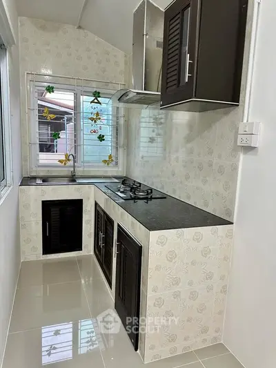 Charming kitchen with modern gas stove and sleek cabinetry, perfect for culinary enthusiasts.