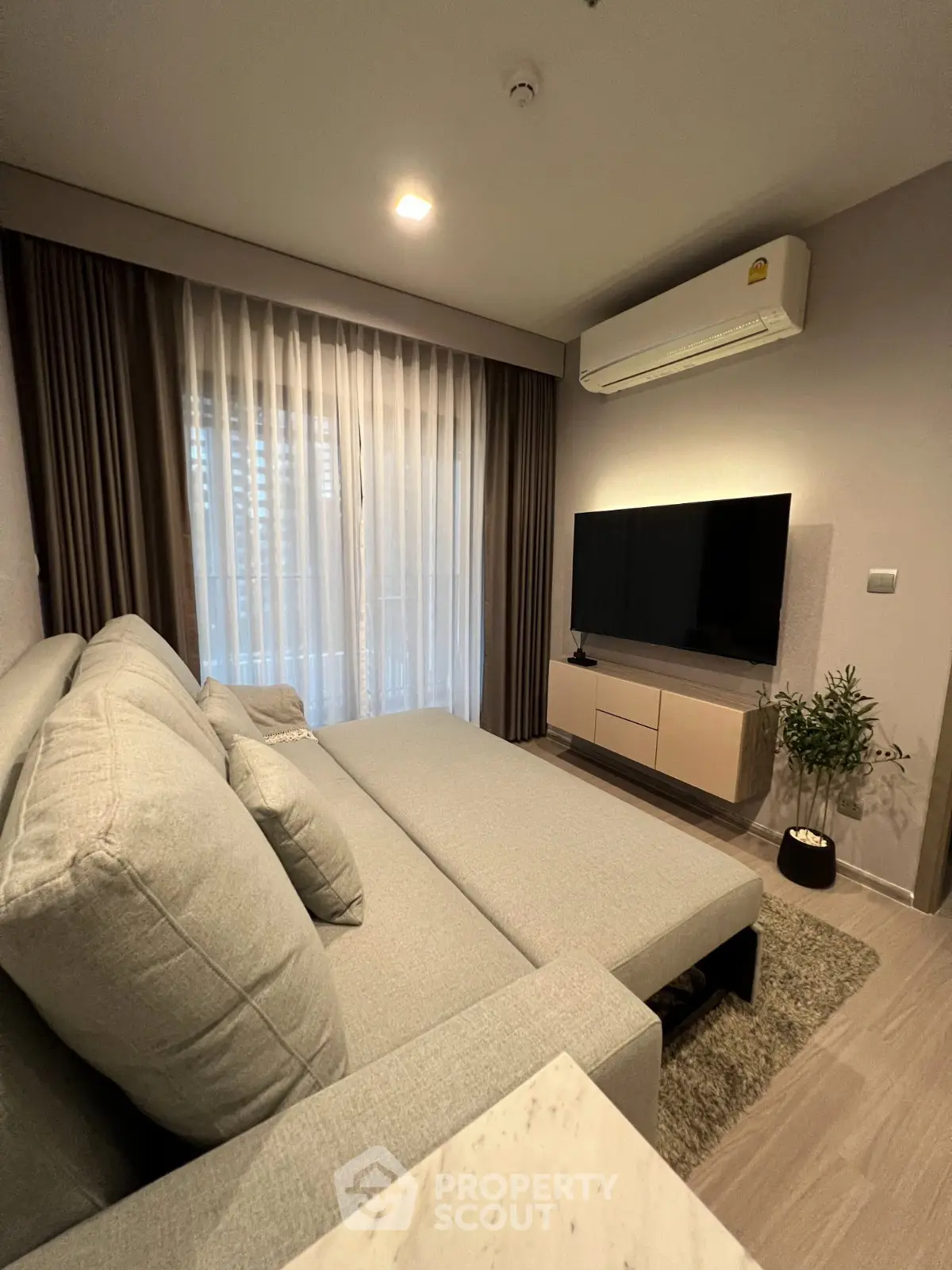 Modern living room with sleek furniture and large TV, perfect for relaxation and entertainment.