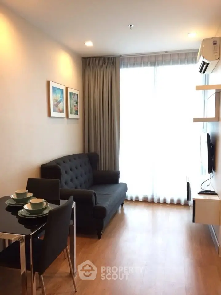 Modern living room with elegant decor and natural light, featuring a cozy sofa and dining area.