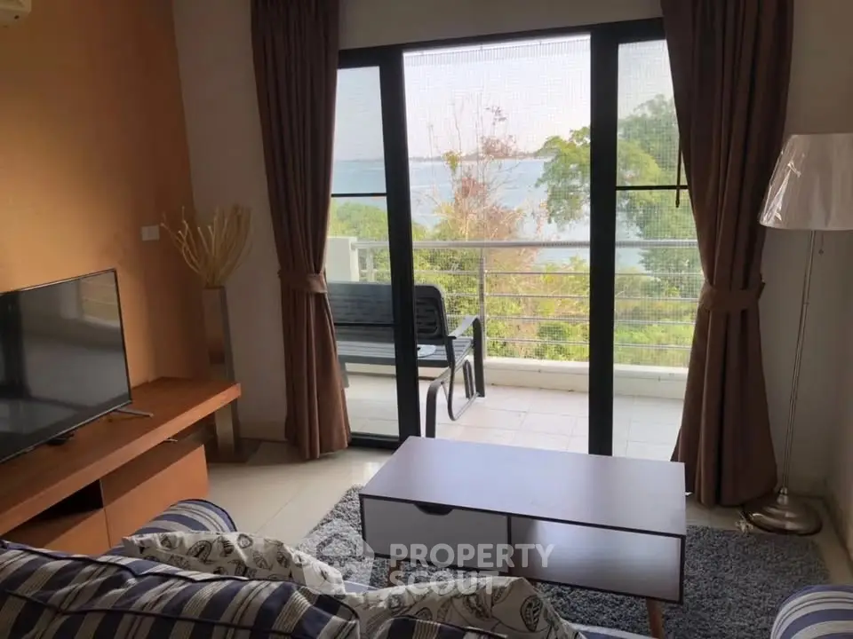 Charming living room with balcony offering stunning nature views, perfect for relaxation and comfort.