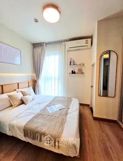 Cozy modern bedroom with wooden flooring and natural light