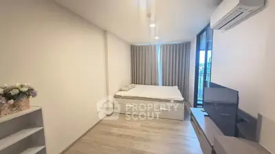Modern bedroom with minimalist design, featuring a cozy bed, air conditioning, and a sleek TV setup.