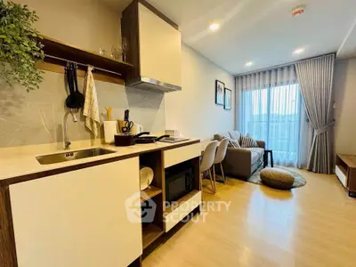 Modern open-layout kitchen and living room with stylish decor and natural light.
