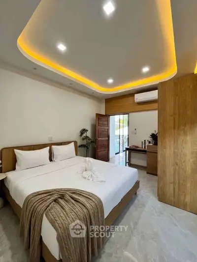 Modern bedroom with stylish lighting and wooden furniture, featuring a cozy bed and balcony access.
