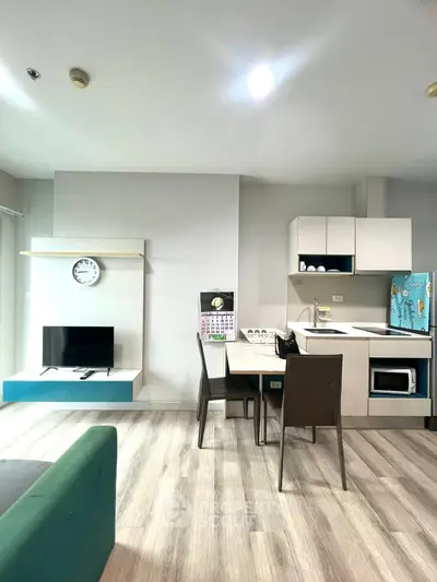 Modern open-plan living room with sleek kitchen and dining area, featuring contemporary furniture and stylish decor.