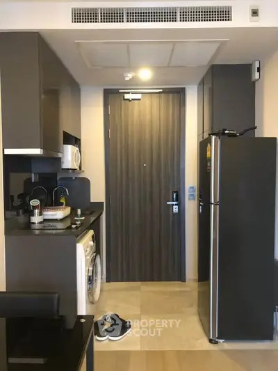 Modern kitchen with sleek appliances and compact design in urban apartment.