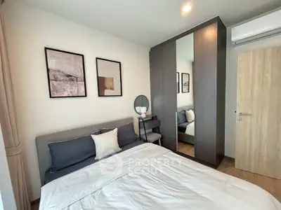 Modern bedroom with stylish decor and mirrored wardrobe in a cozy apartment.