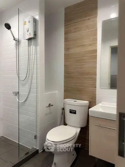 Modern bathroom with glass shower and sleek fixtures in contemporary apartment.