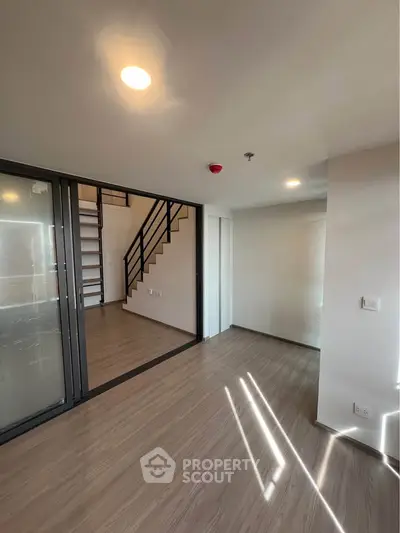 Modern duplex apartment with sleek staircase and ample natural light.