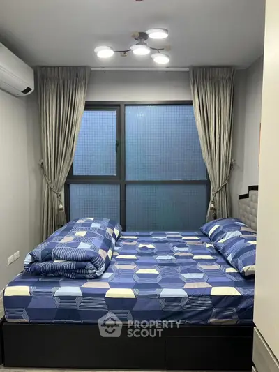 Cozy bedroom with modern decor and large window, featuring stylish bedding and elegant curtains.