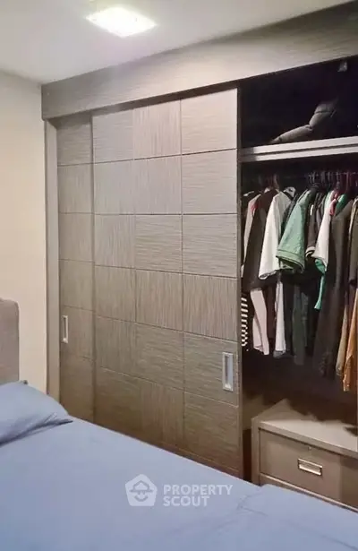Modern bedroom with built-in wardrobe and cozy bedding, perfect for urban living.