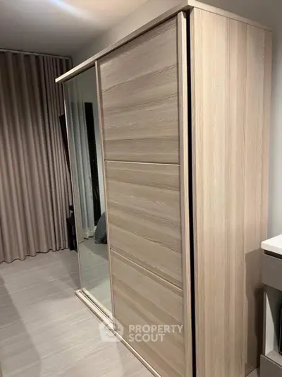 Modern bedroom with sleek wooden wardrobe and elegant curtains