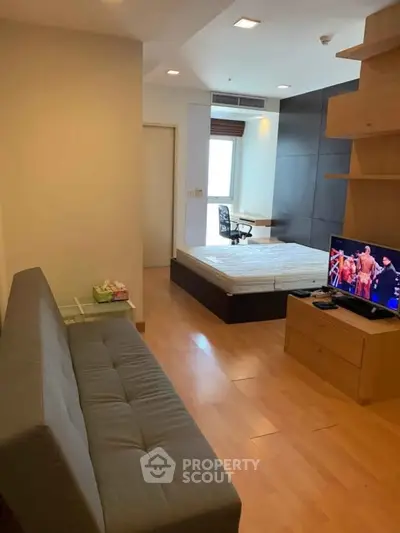 Modern studio apartment with wooden flooring and cozy furnishings.