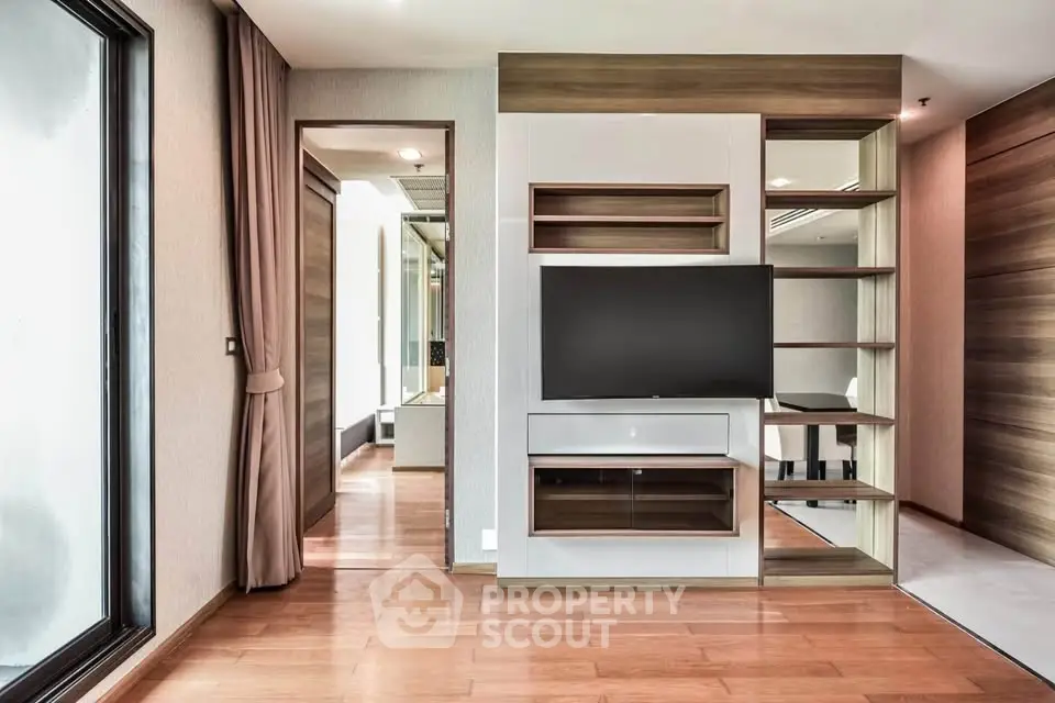 Modern living room with built-in TV unit and wooden flooring