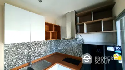 Modern kitchen with sleek cabinetry and stylish backsplash in a compact layout.