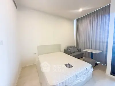 Modern bedroom with cozy seating area and natural light