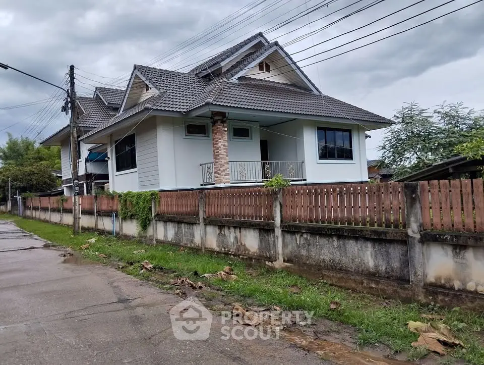 Charming suburban house with a fenced yard and sloped roof, perfect for family living.