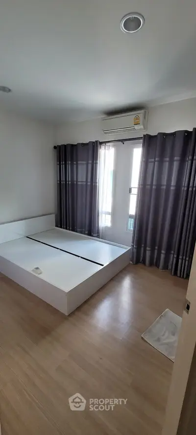 Spacious bedroom with modern design and large windows for natural light.