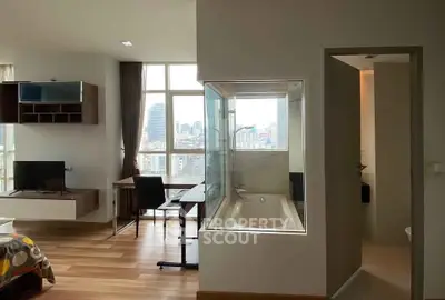 Modern studio apartment with city view, featuring a unique in-room bathtub and stylish furnishings.