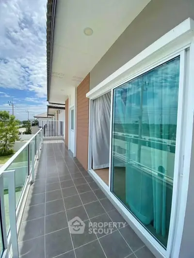 Spacious balcony with glass railing and scenic view in modern home
