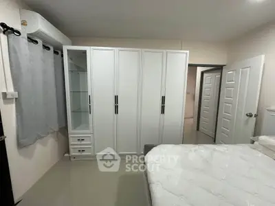 Spacious bedroom with modern white wardrobe and comfortable bed