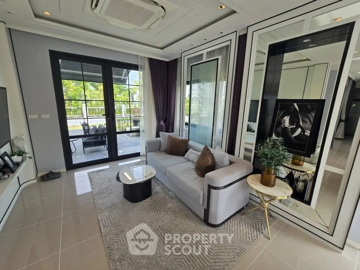 Luxurious living room with modern decor and large windows opening to a scenic balcony view.
