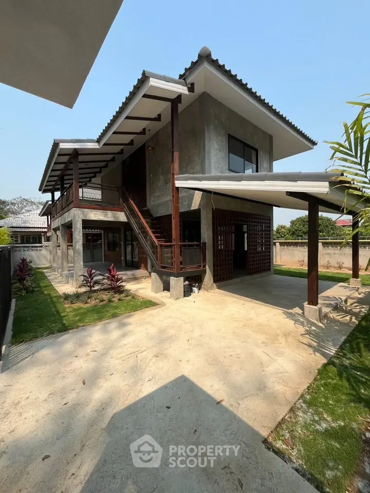 Modern two-story house with unique architectural design and spacious outdoor area.