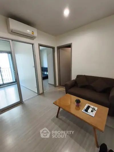 Modern living room with air conditioning and cozy sofa, featuring a sleek coffee table.