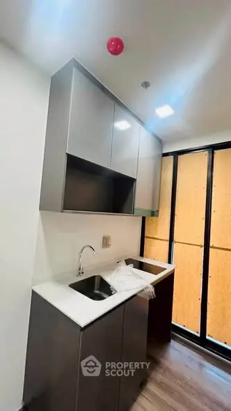 Modern kitchen with sleek cabinetry and large window for natural light.