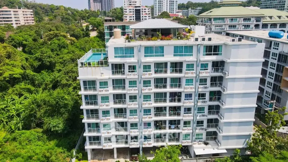 Modern multi-story apartment building with lush greenery and city views, ideal for urban living.