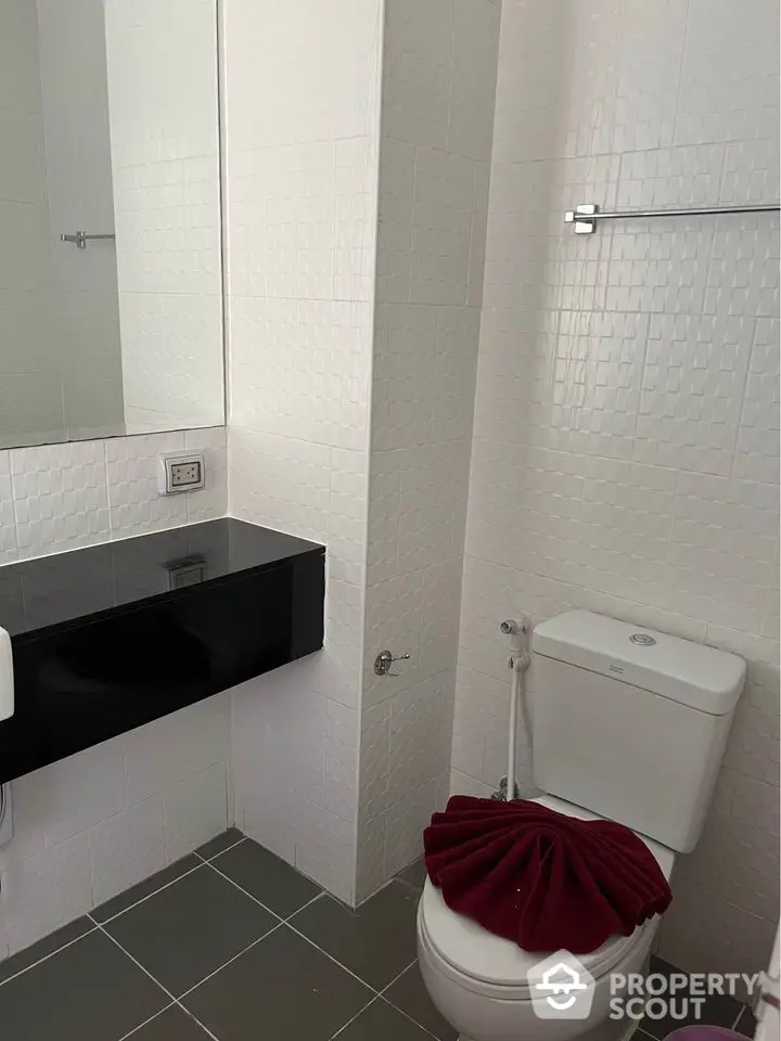 Modern bathroom with sleek black countertop and white tiled walls