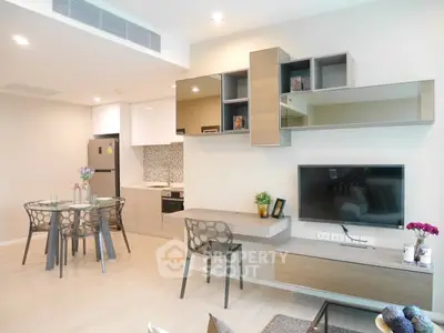 Modern open-plan living room with stylish kitchen and dining area, featuring sleek furniture and contemporary decor.