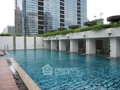 Luxurious rooftop pool with city skyline view in modern high-rise building.