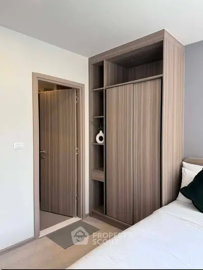 Modern bedroom with built-in wooden wardrobe and cozy bed setup.