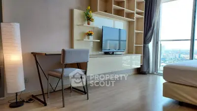 Modern bedroom with stylish TV setup and city view, featuring sleek furniture and natural light.