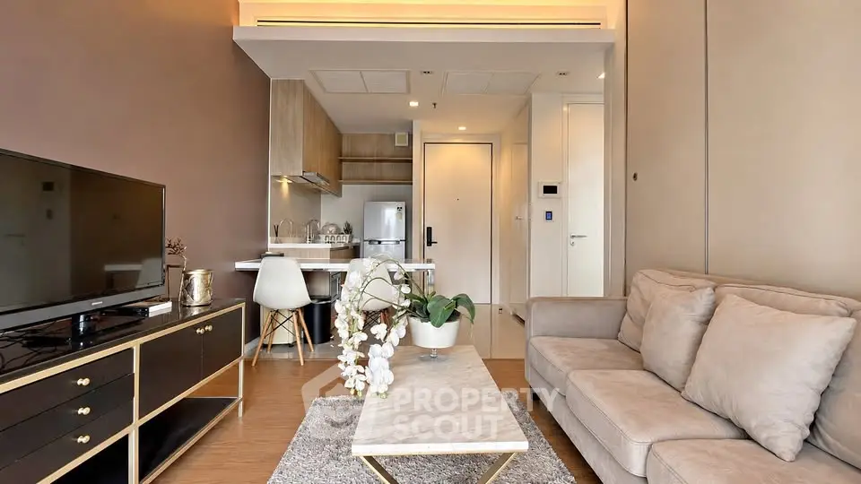Modern living room with cozy sofa and stylish kitchen in open layout apartment.