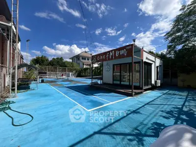 Unique outdoor space with blue court and modern structure under clear sky