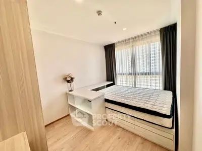 Modern bedroom with large window and built-in storage in a high-rise apartment.