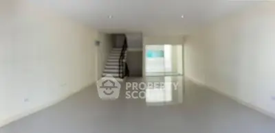 Spacious empty living room with glossy floors and staircase, ideal for customization.