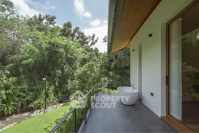 Luxurious balcony with freestanding bathtub and lush green view, perfect for relaxation and nature lovers.