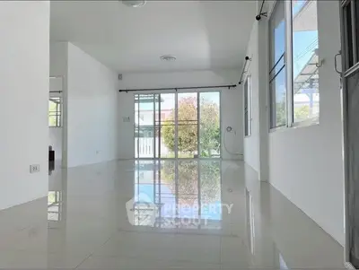 Spacious empty living room with large windows and glossy tiled floors
